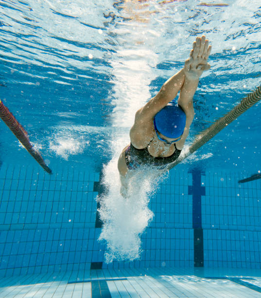 young female swimmer diving in the pool